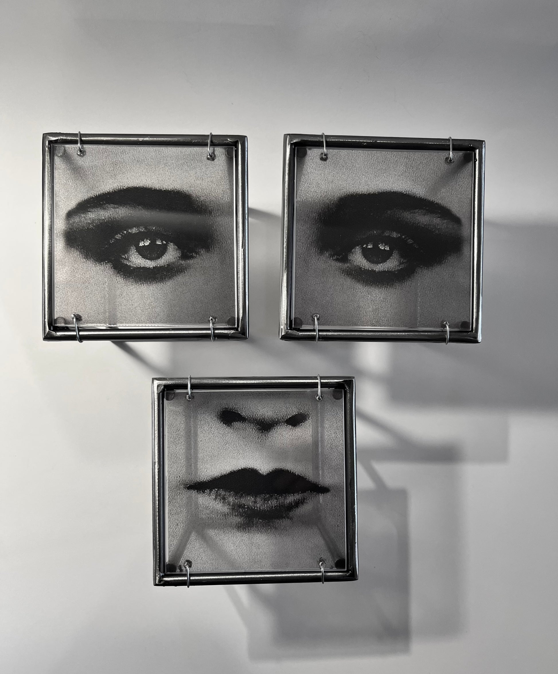 # view projecting from wall of three piece black and white print of female eyes and mouth on transparent acetate mounted in steel frames. Modern Interior Metal Wall Art Sculpture Pop art face - Designer wall art Artandshadowntal