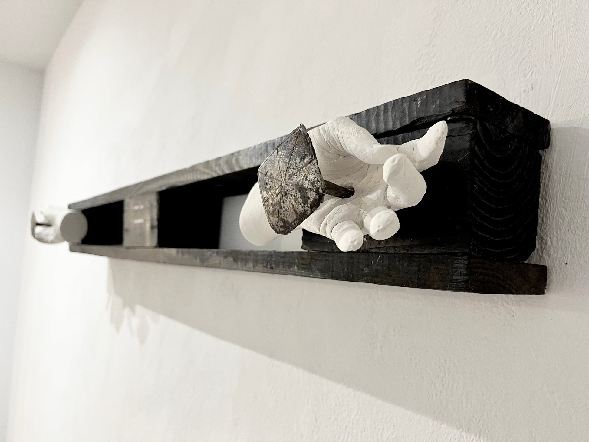 close up of one of the two artists hands caste in plaster and crucified onto wood an antique decorative forged nails