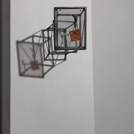 video of social explosion wall sculpture with shadow emphasizing steel bar construction.