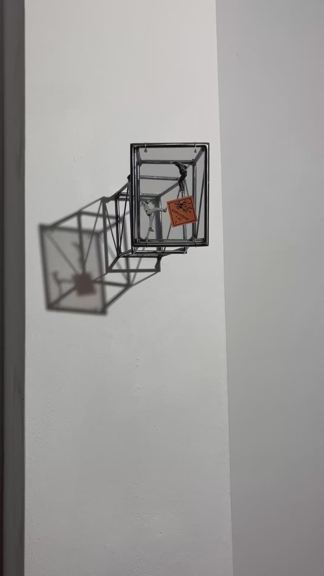 video of social explosion wall sculpture with shadow emphasizing steel bar construction.