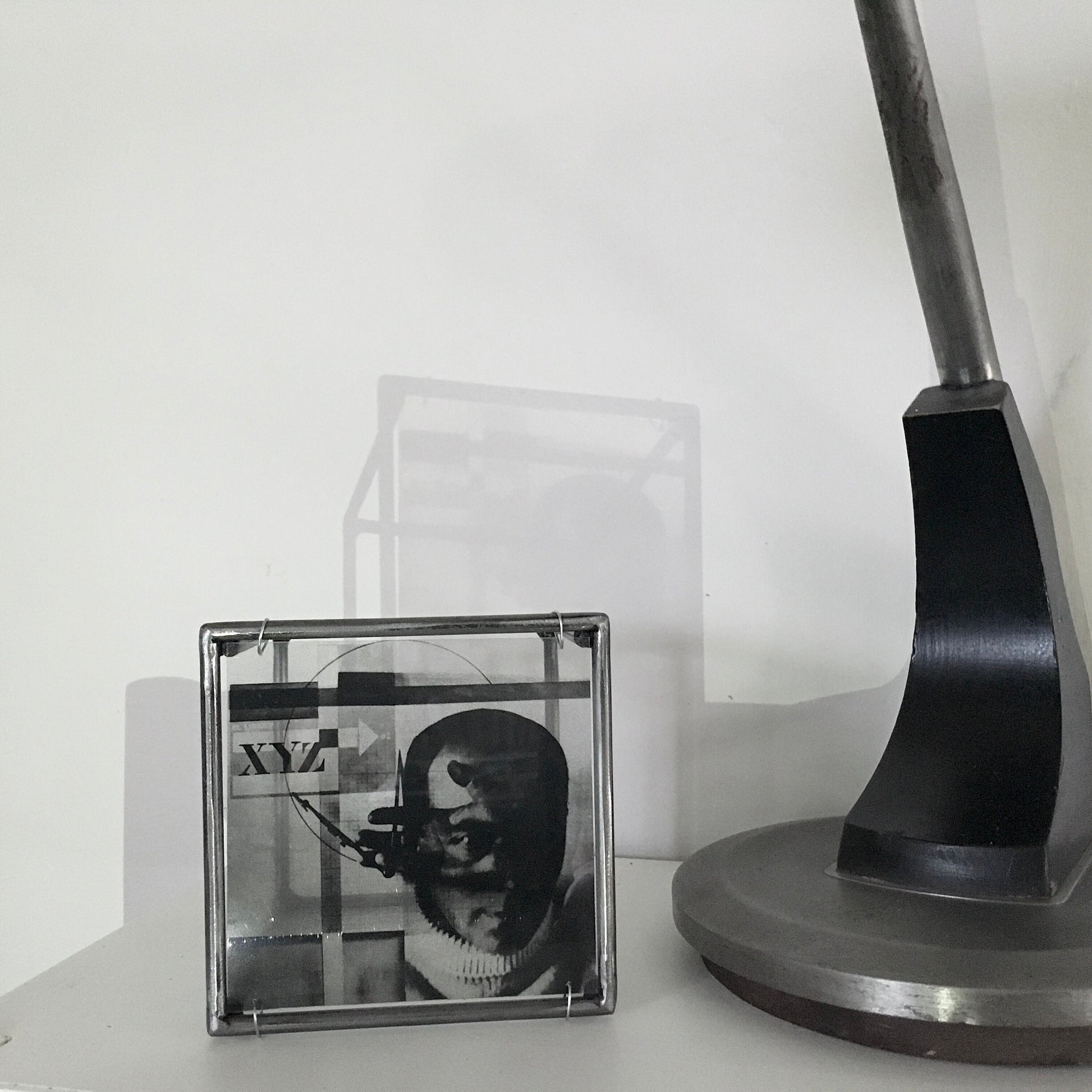 El Lissitzky, self portrait photo collage - Metal art sculpture hand of god symbol next to desk lamp desk top art piece